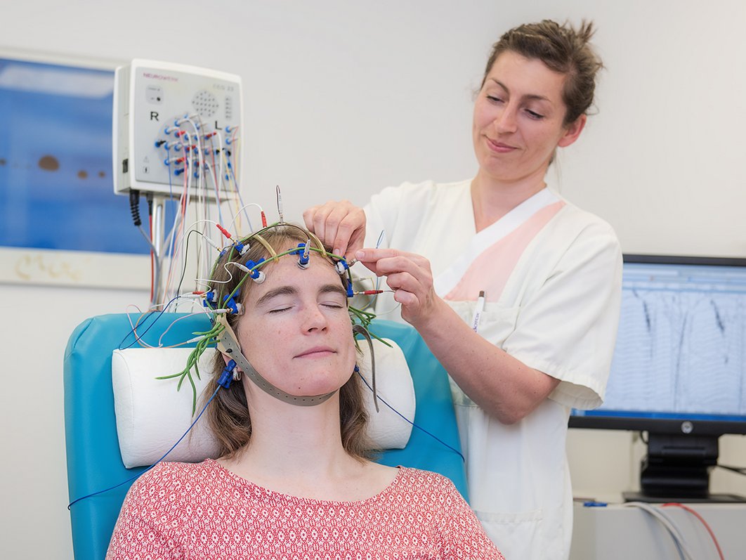 Frau legt einer Frau EEG-Messfühler an