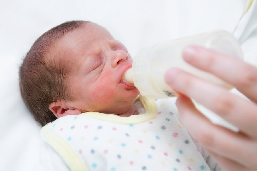 Baby bekommt Milch in einem Fläschchen  Baby bekommt Milch in einem Fläschchen