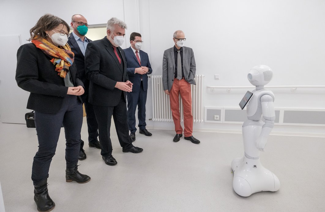 Eröffnung des Erxleben Digital HealtCare Hub: Vertreter:innen aus Politik und Wissenschaft schauen auf den Roboter Pepper