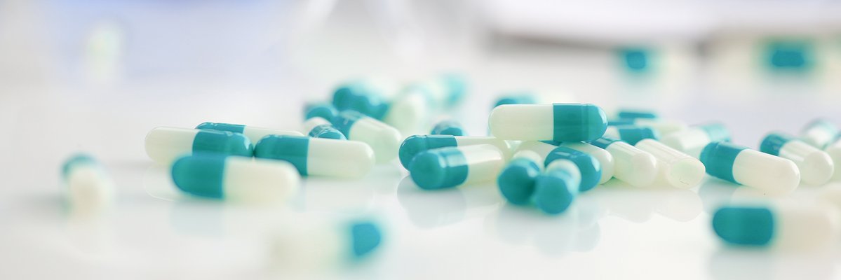 Tabletten, Kapseln in blau-weiß auf einer weißen Platte