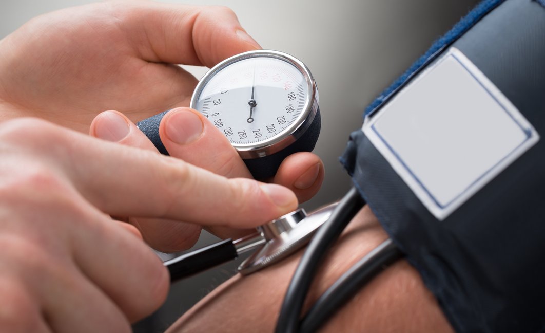 Blutdruckmessgerät an einem Arm, Hände halten Geräte