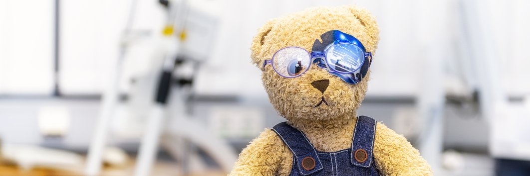 Teddy mit zugeklebten Auge und Brille in der Kindersprechstunde