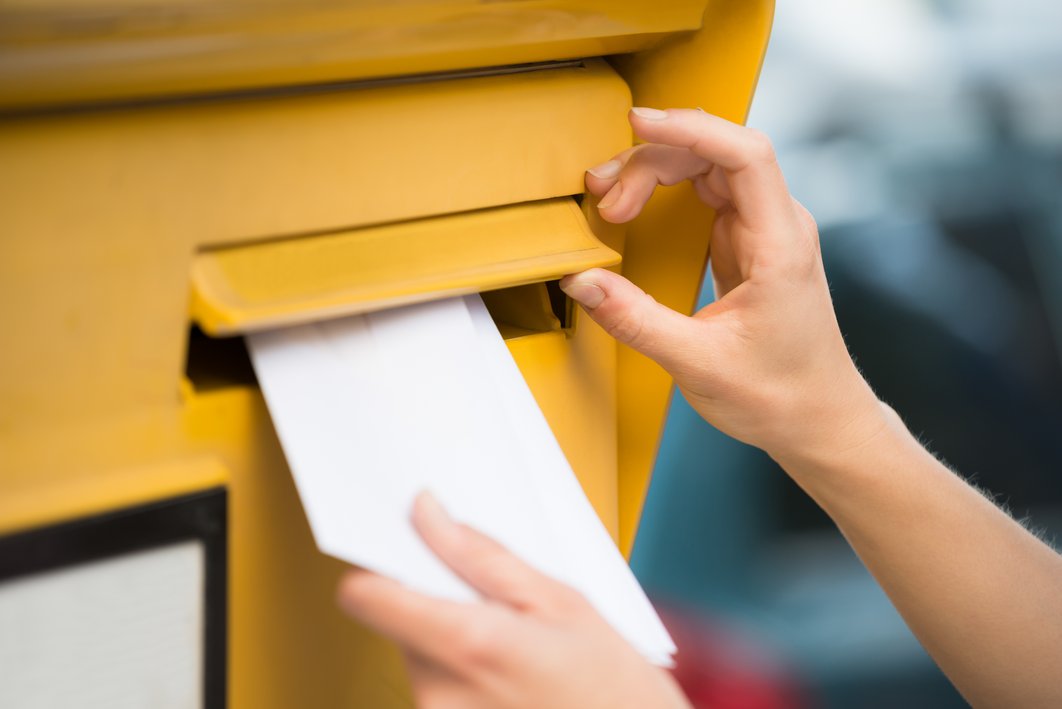 Ein Brief wird in einen Briefkasten gesteckt