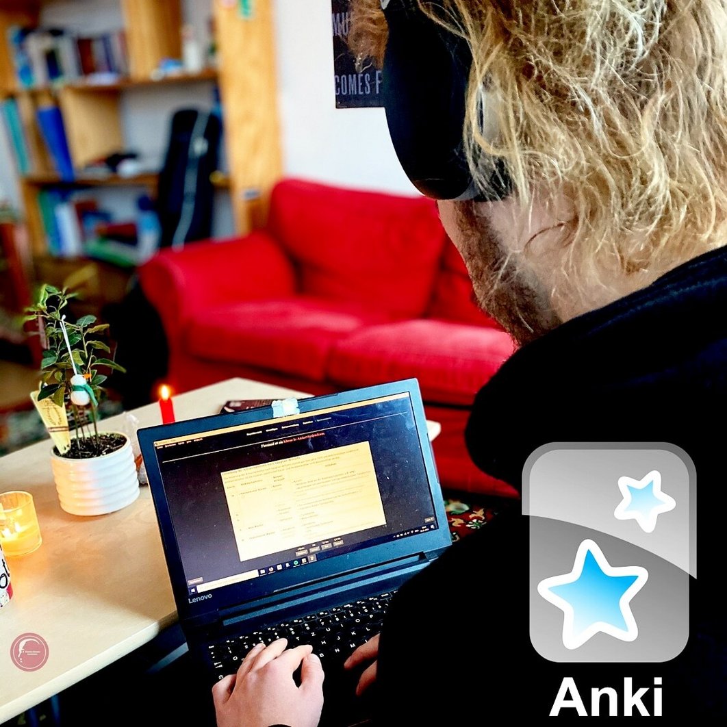 Eine Person schaut auf einen Laptop-Monitor. Die Person trägt ein Headset, im Hintergrund ist ein Wohnzimmer zu sehen. Vorne ist das Logo von "Anki" zu sehen.