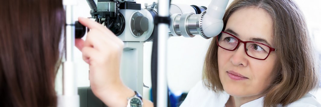 Eine Ärztin untersucht mit einem speziellem Gerät die Augen einer Patientin
