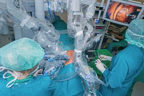OP-Roboter und Operateure in grüner Schutzkleidung während einer Operation.